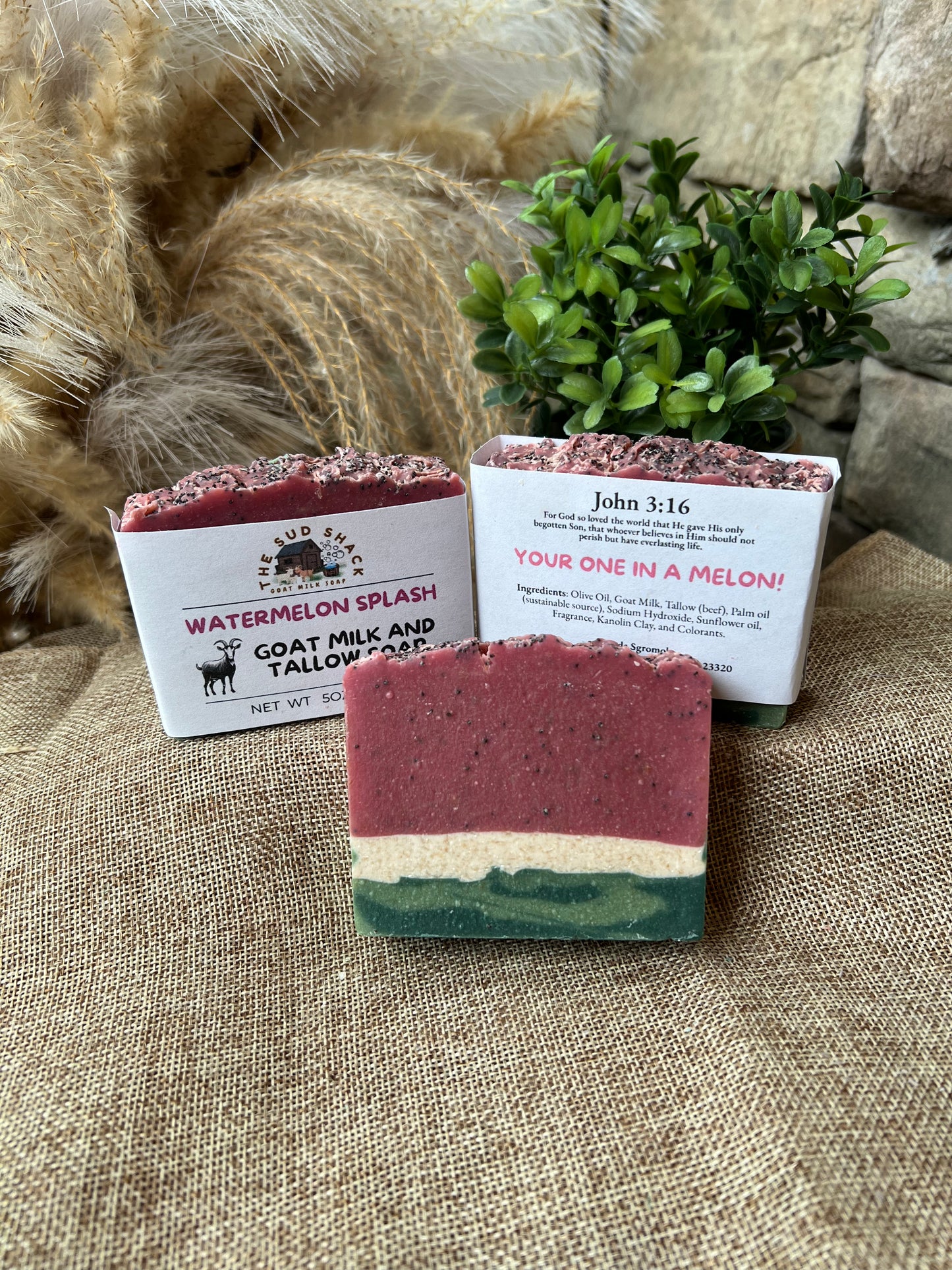 Three bars of soap with visible branding on a textured surface with decorative elements.