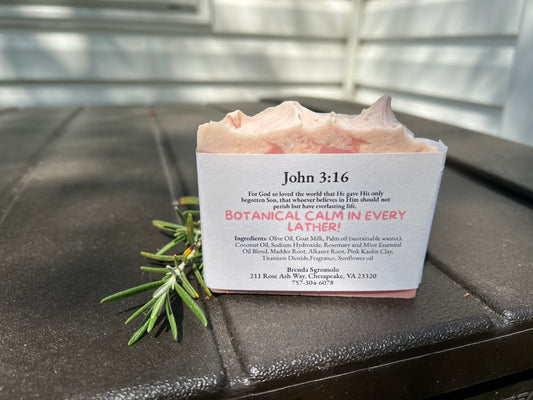 Bar of soap with rosemary and mint essential oils and John 3:16 verse on the back with a black surface