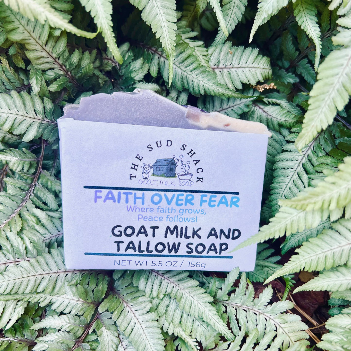 Bar of soap with 'The Sud Shack' branding on a bed of green ferns