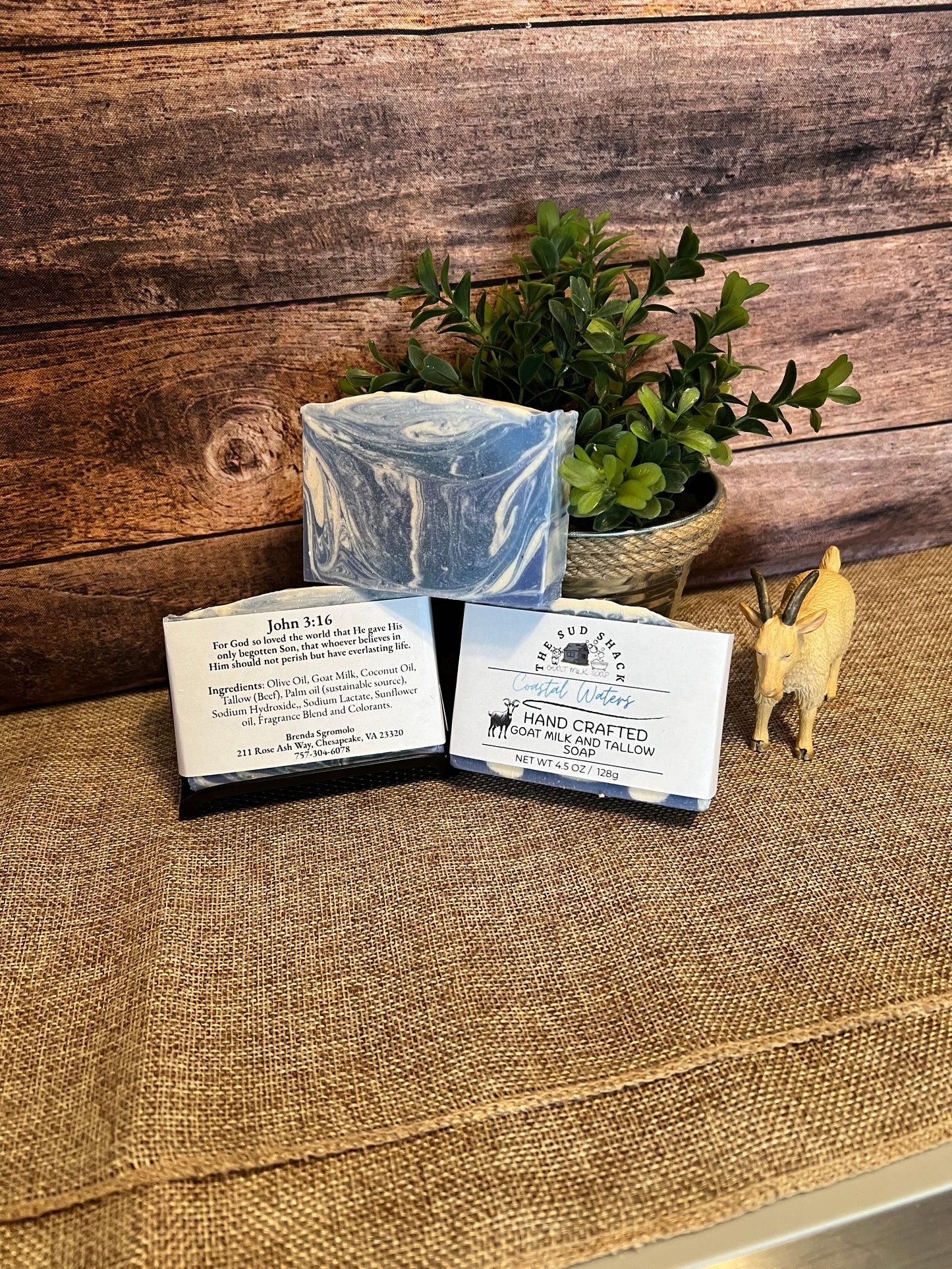 Two soap bars with packaging on a textured surface with a wooden background