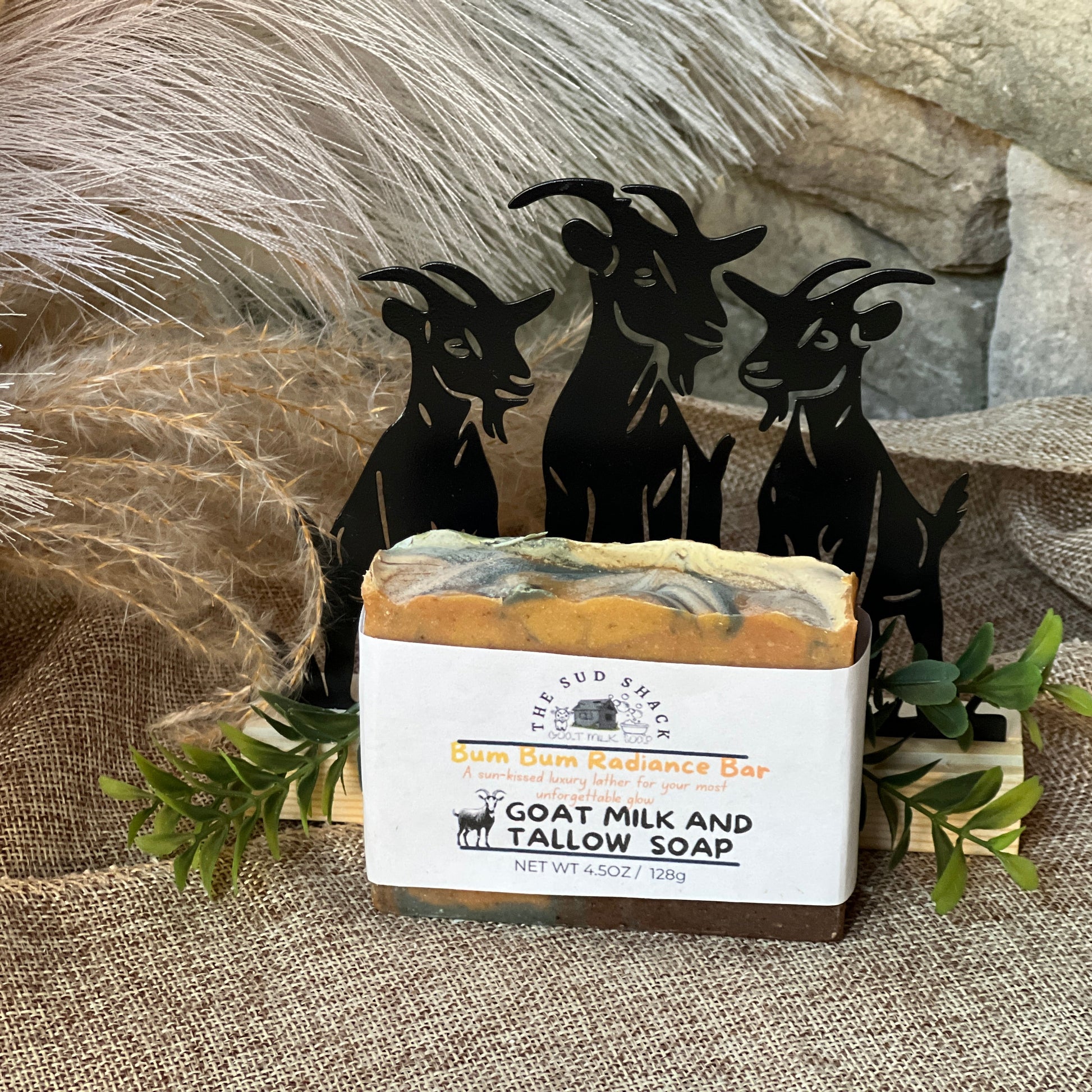 Goat milk and tallow soap bar with decorative goat figures on a textured surface