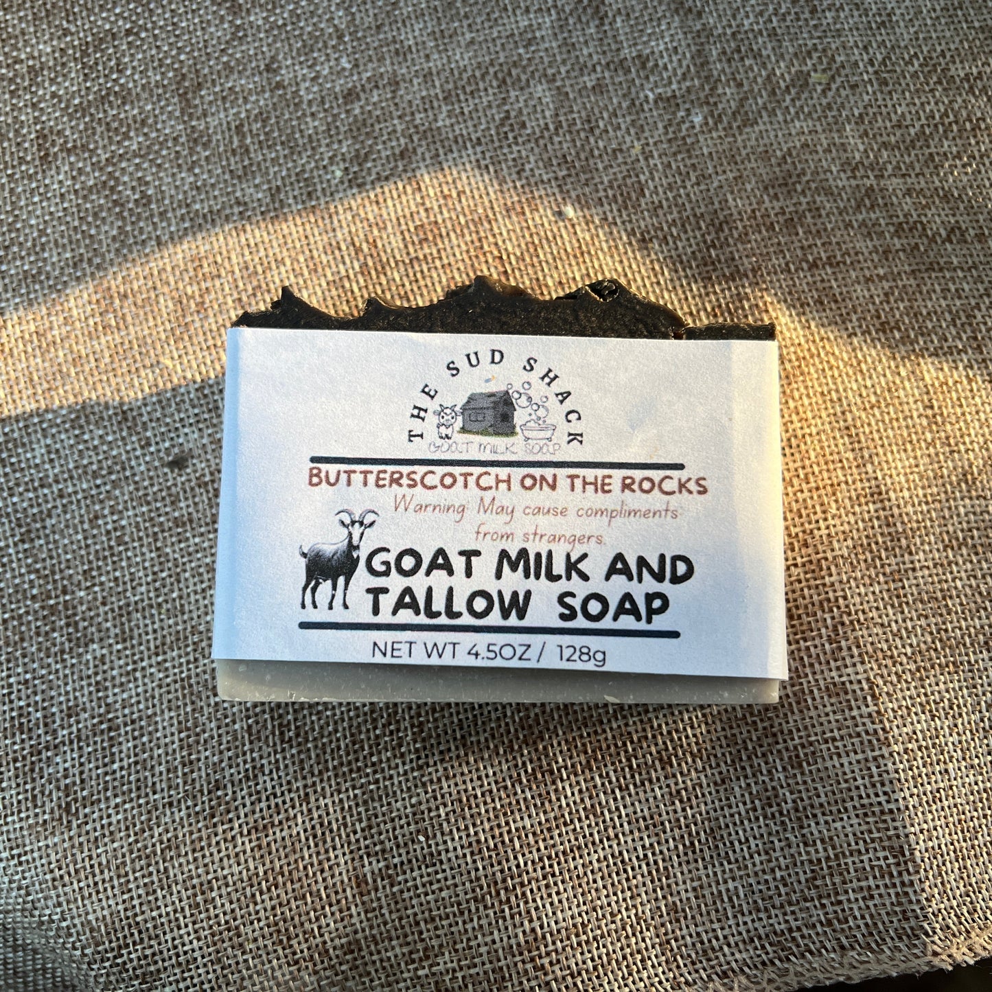 Bar of soap with a label on a textured fabric background