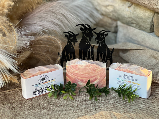 Three bars of soap with visible branding on a textured surface with decorative elements.