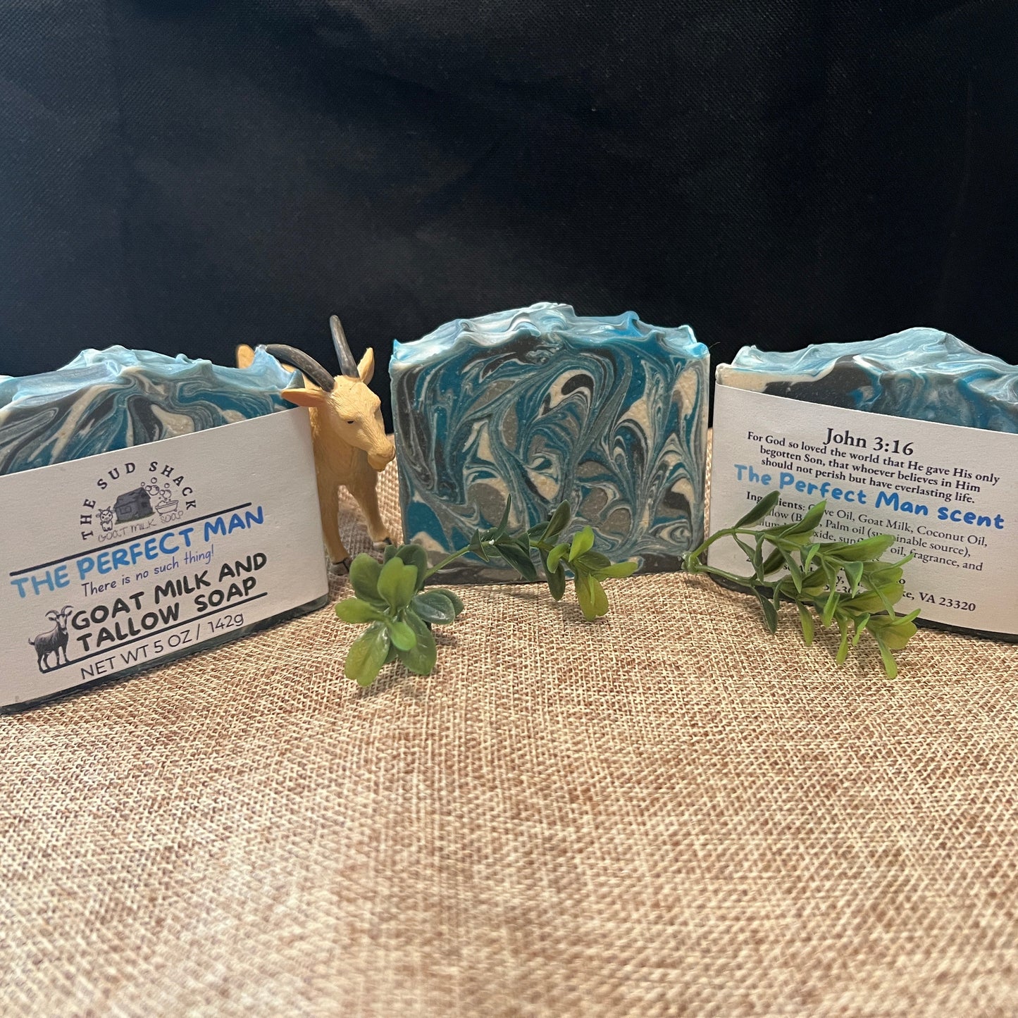 Three bars of soap with decorative labels on a textured surface