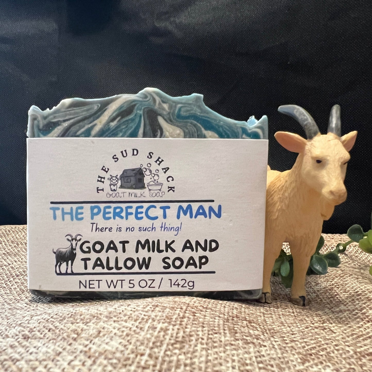 Bar of soap with 'The Sud Shack' branding and a goat figurine on a textured surface.