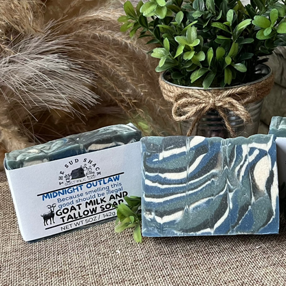 Three soap bars with packaging on a stone surface with decorative elements.