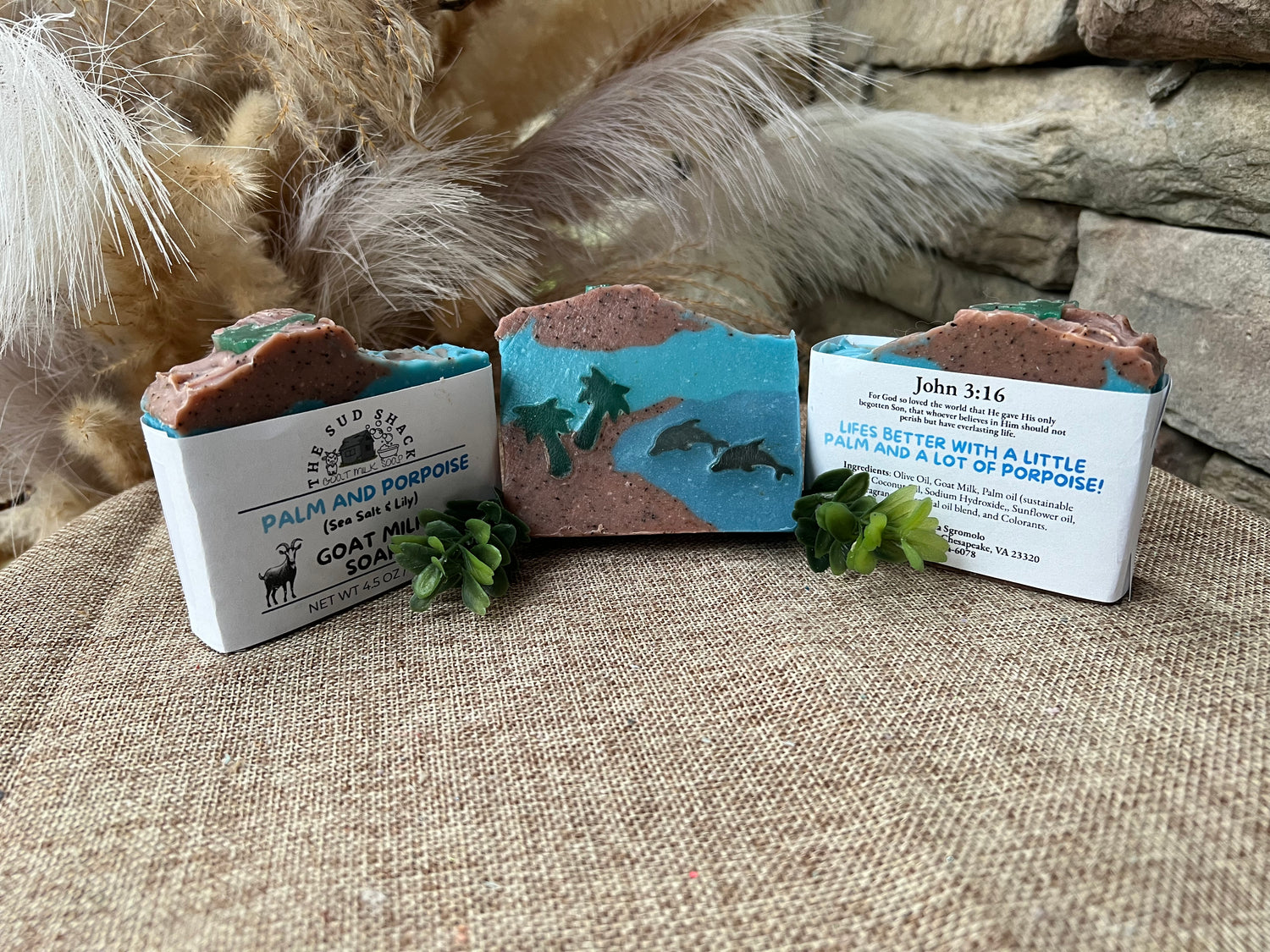 Three soap bars with labels on a textured surface