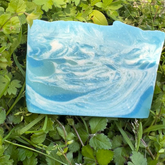 Blue and white swirled soap bar on green grass
