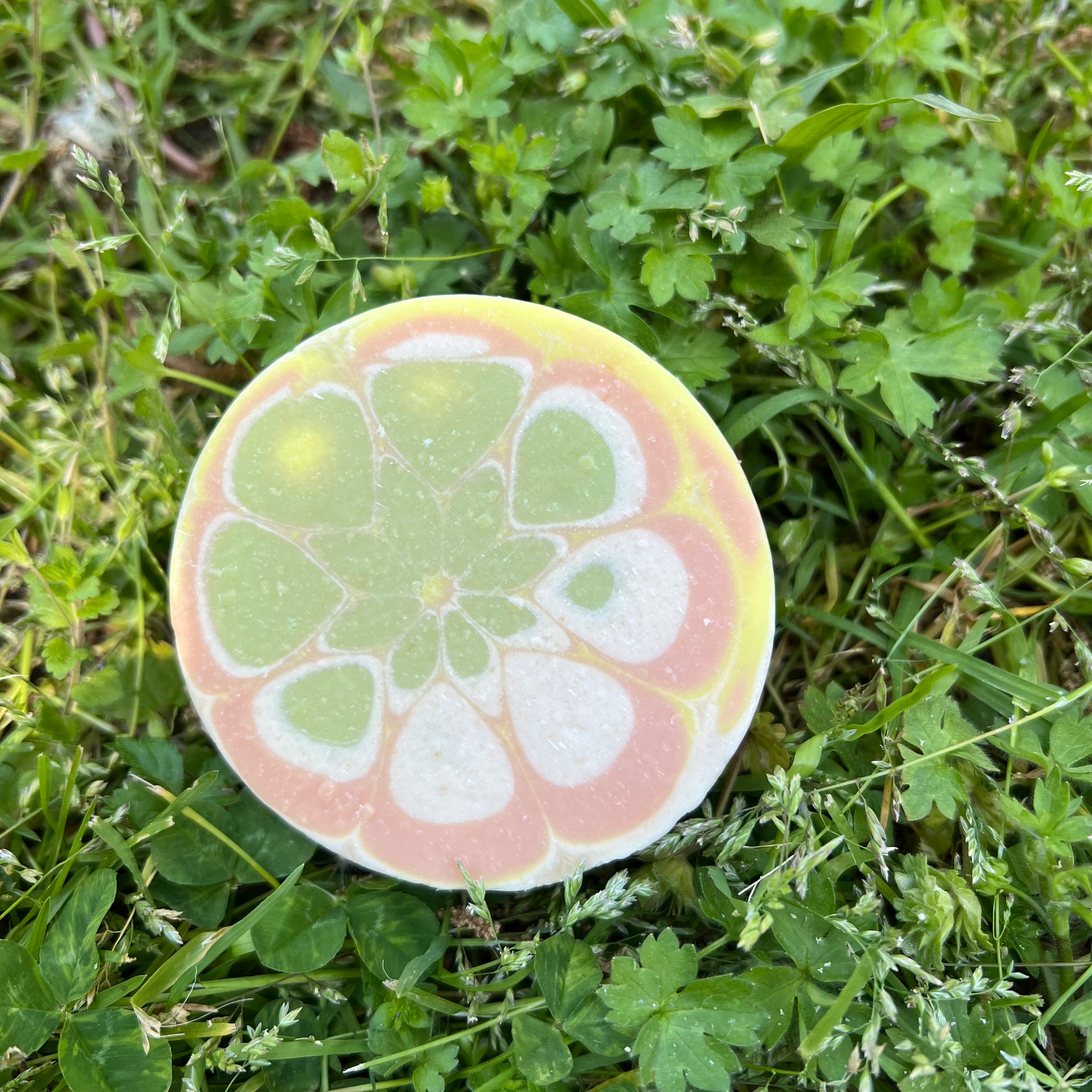 Round decorative stone with a floral pattern on grass