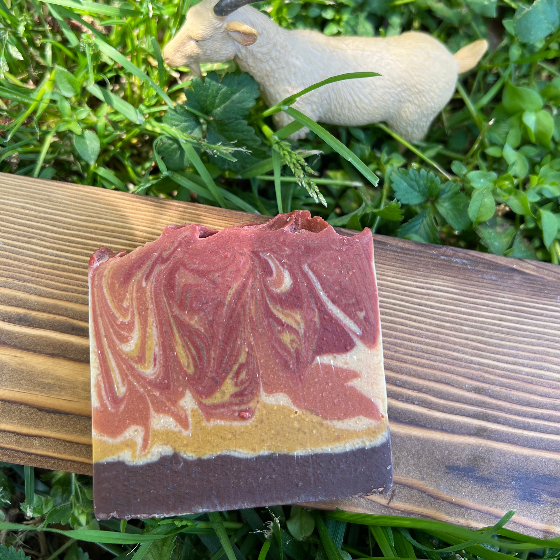 Bar of soap with marbled design on a wooden block outdoors