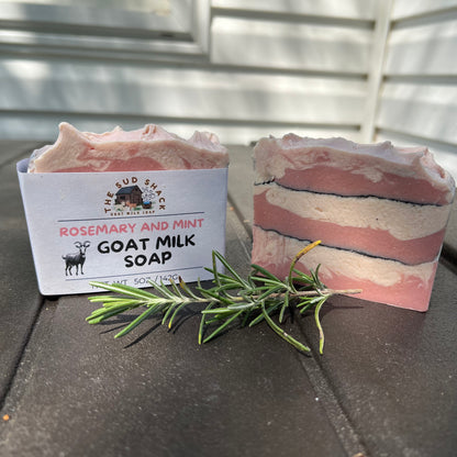 Goat milk soap with rosemary and mint essential oils,  displayed with a label on a dark surface.