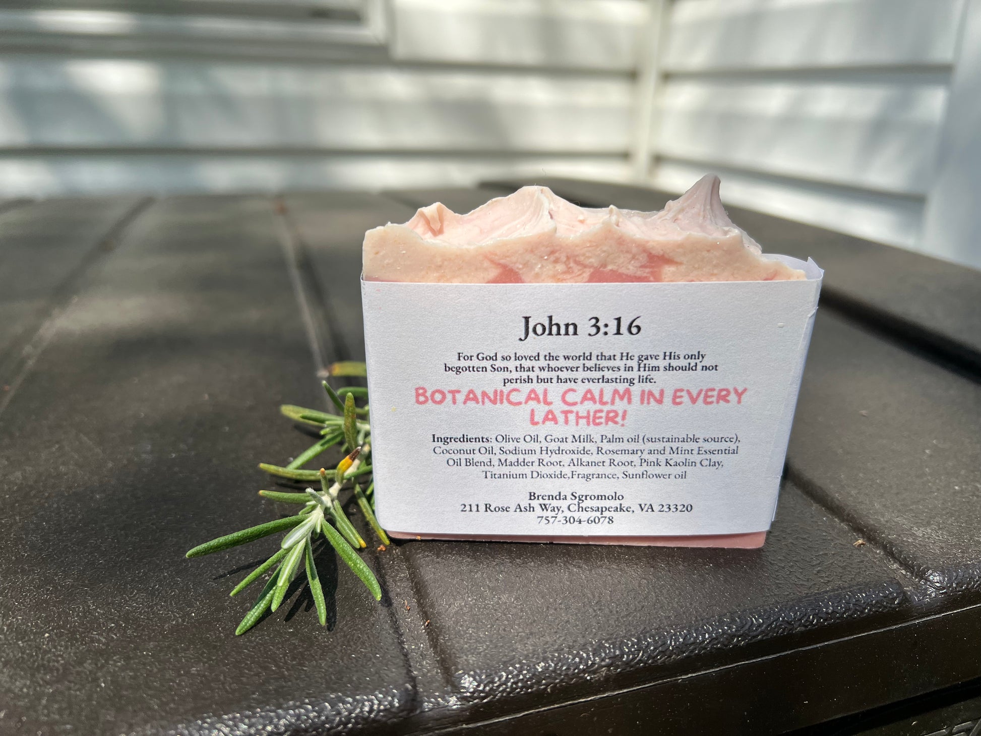 Bar of soap with rosemary and mint essential oils and John 3:16 verse on the back with a black surface