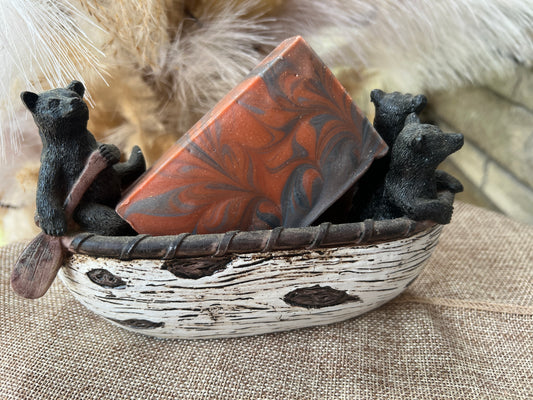 Decorative soap with bear figurines in a boat on a textured surface