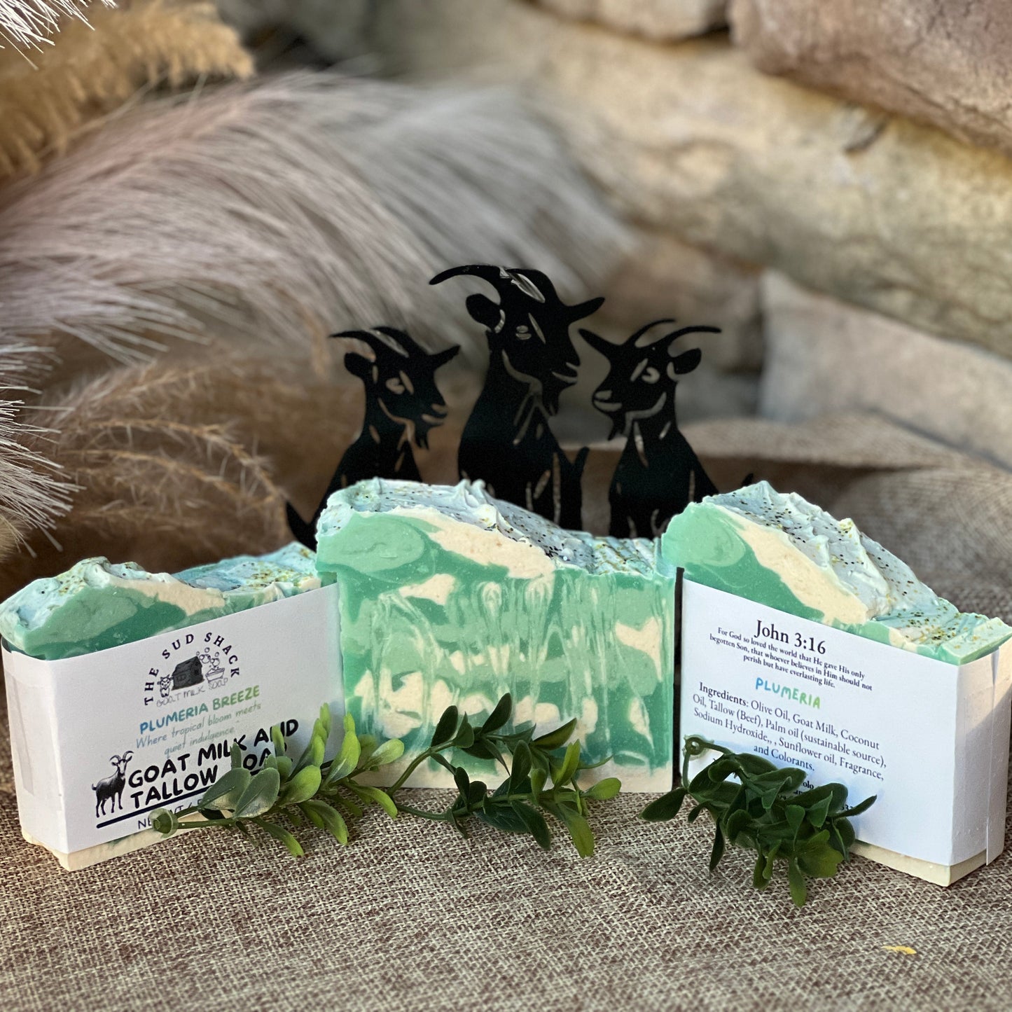 Three bars of soap with labels and decorative elements on a textured surface.