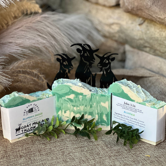 Three bars of soap with labels and decorative elements on a textured surface.