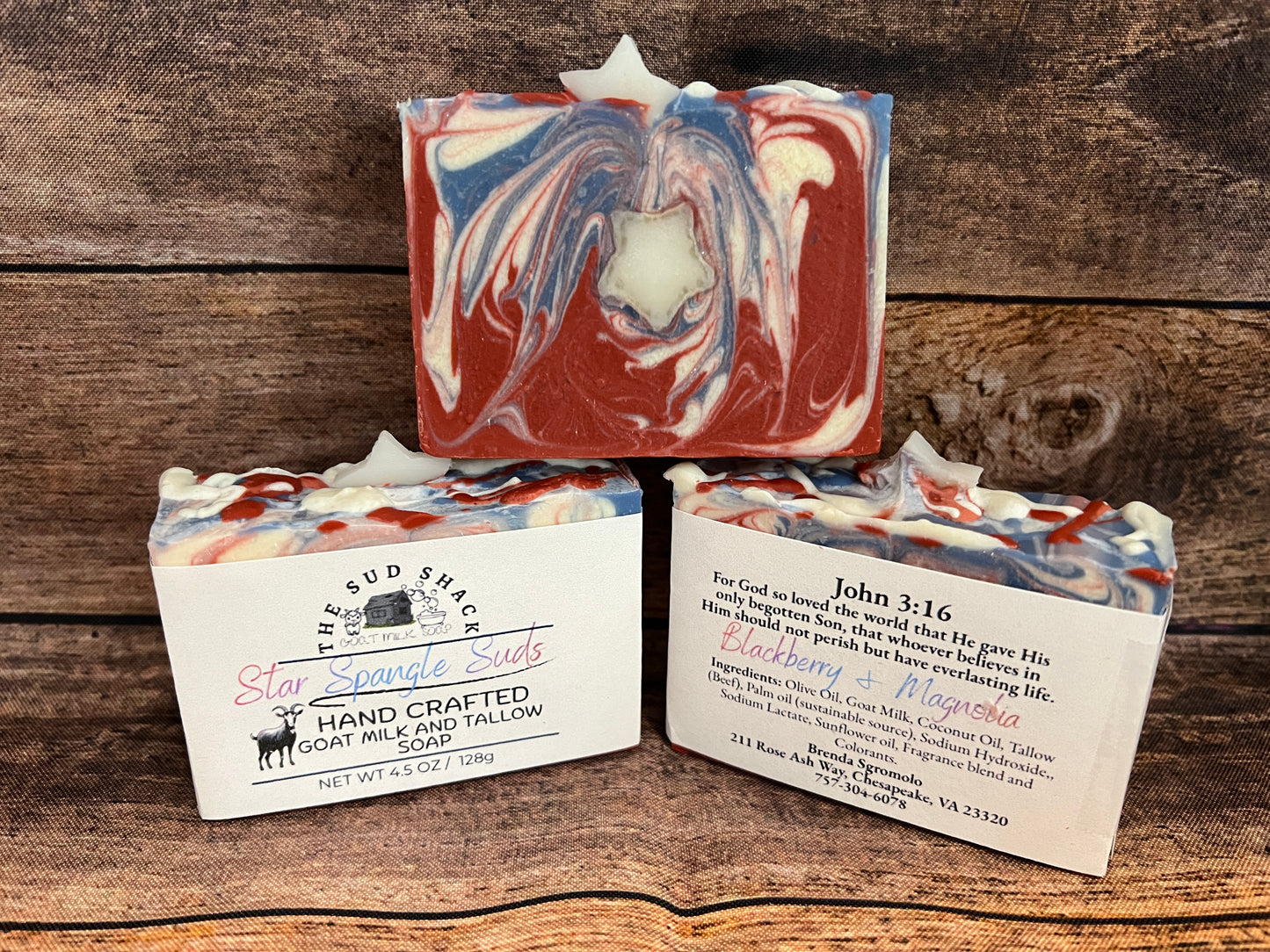 Three handcrafted soap bars with labels on a wooden background