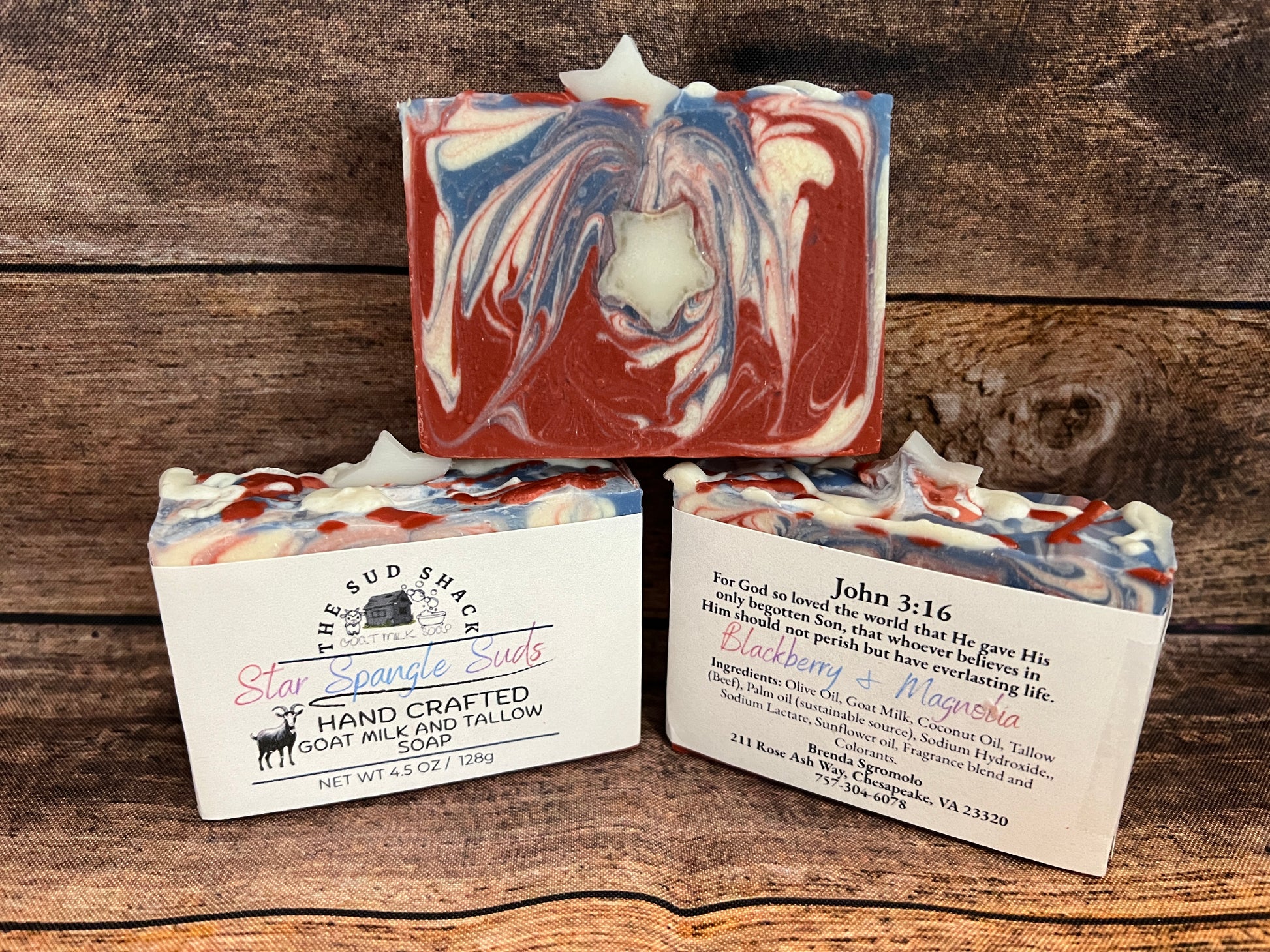 Three handcrafted soap bars with labels on a wooden background