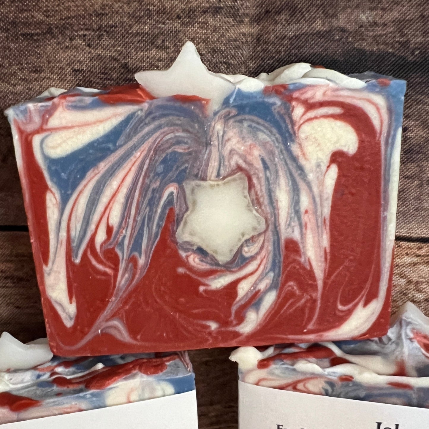 Marbled soap bars with visible brand labels on a wooden surface