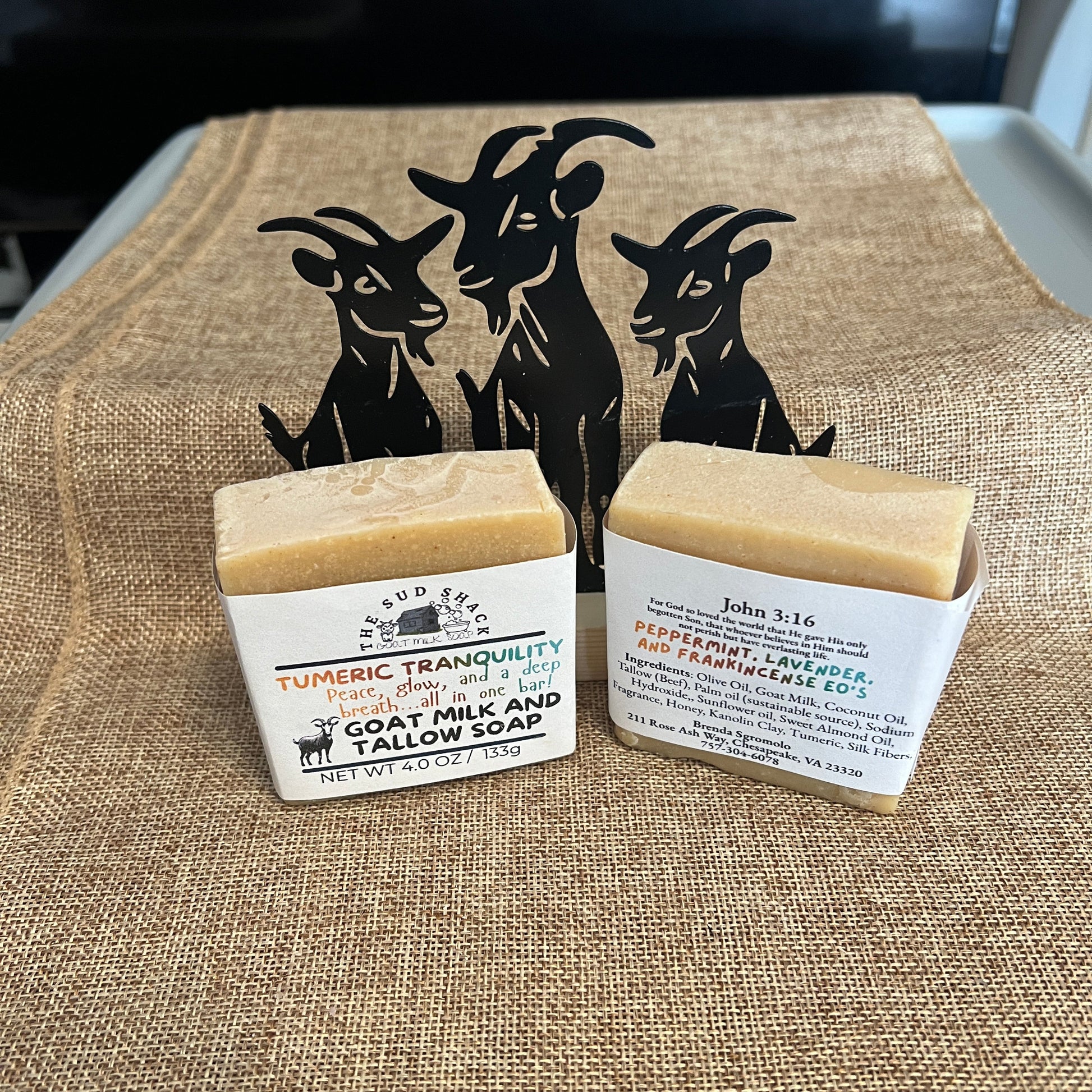 Two bars of soap with labels on a textured fabric background
